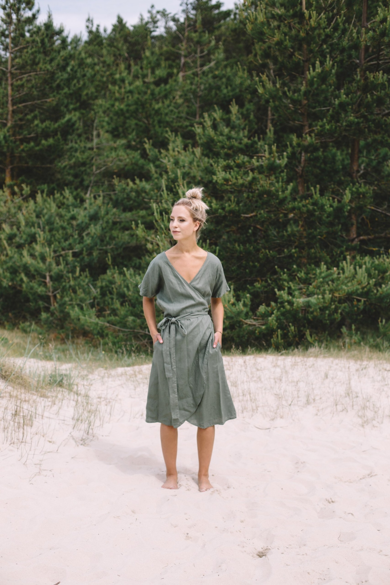 A woman wearing dark green linen wrap dress