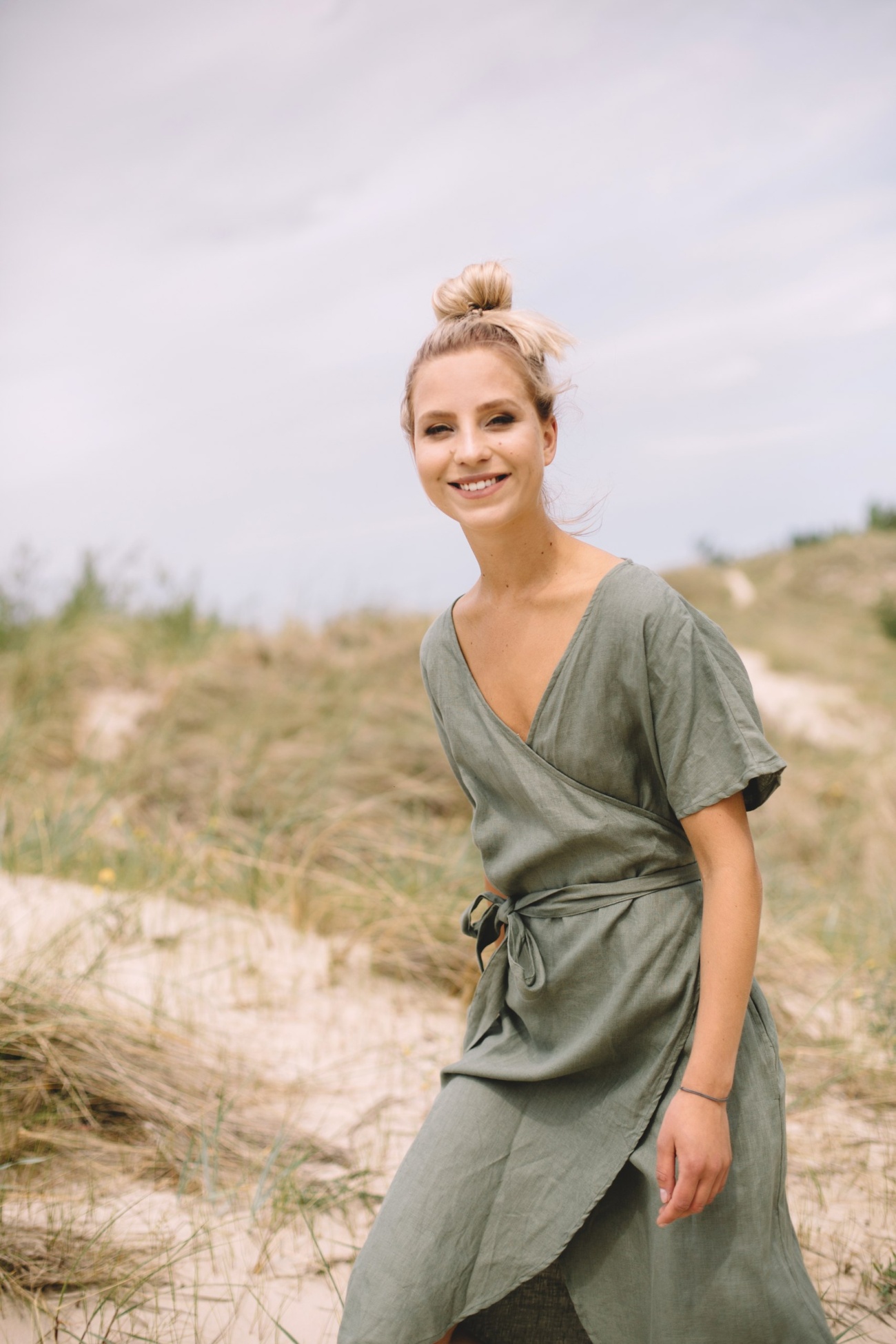 A woman wearing linen wrap dress in dark green