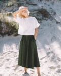 Green linen palazzo and white top set in beach