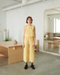 A woman in relaxed yellow gingham linen pants