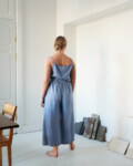 The back of a model wearing wide leg blue linen trousers