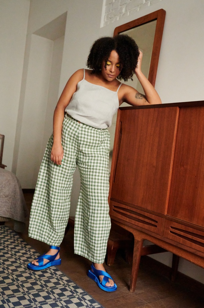 A model in green gingham linen trousers