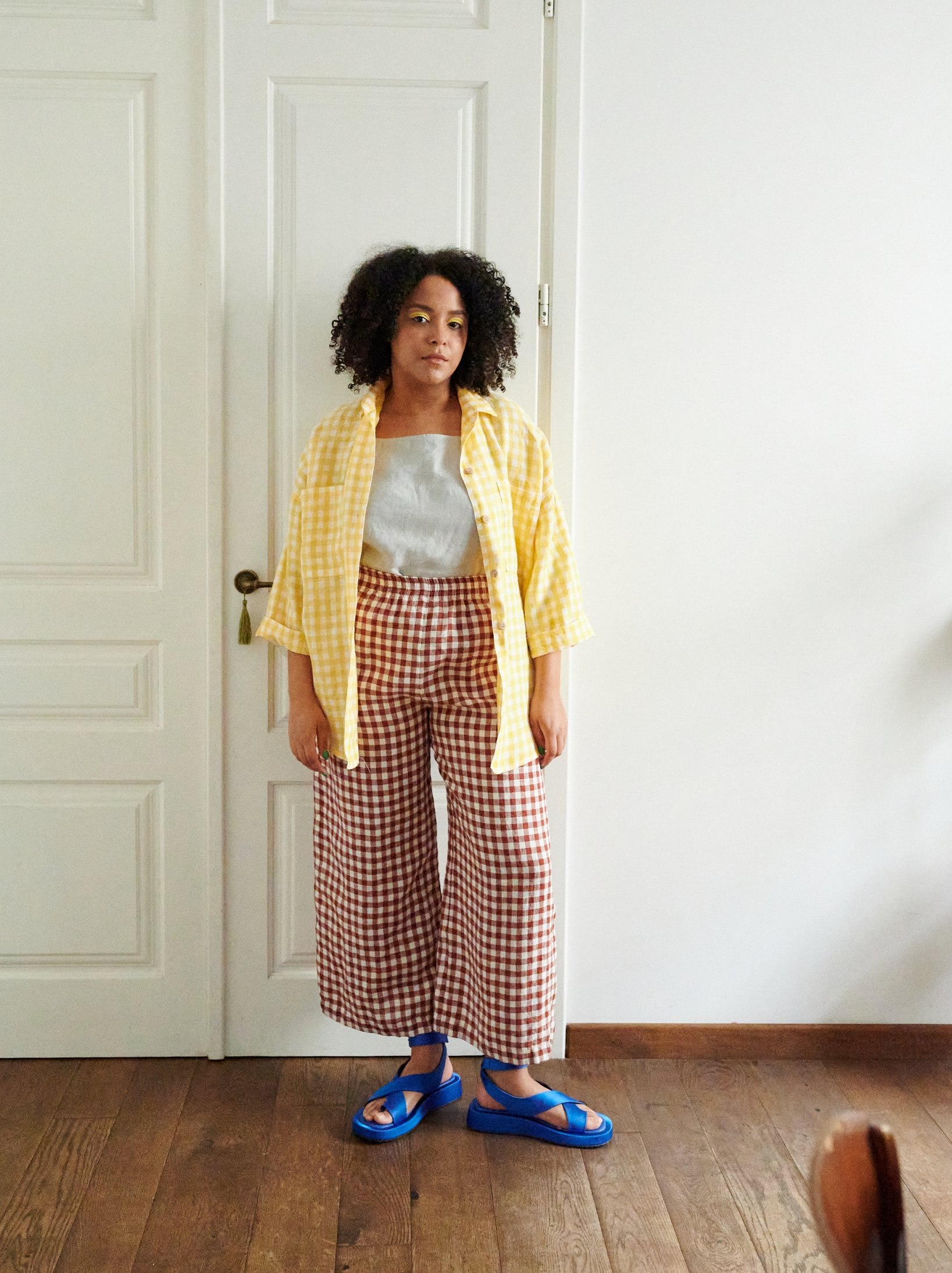Mix of gingham linen tops, trousers, and dresses in earthy tones