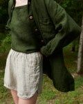 Woman wearing an oversized green waffle linen shirt with a matching linen top and natural grey linen shorts