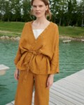 A kimono-style linen jacket worn with a matching belt and wide leg linen trousers