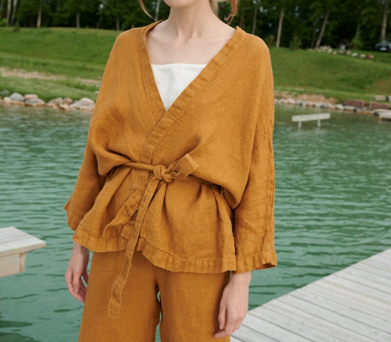 A kimono-style linen jacket worn with a matching belt and wide leg linen trousers
