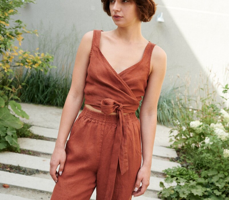 Model wearing a terracotta cropped linen top with matching high-waisted linen trousers