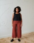 front of model in terracotta wide leg linen trousers paired with a black linen summer top with wide straps