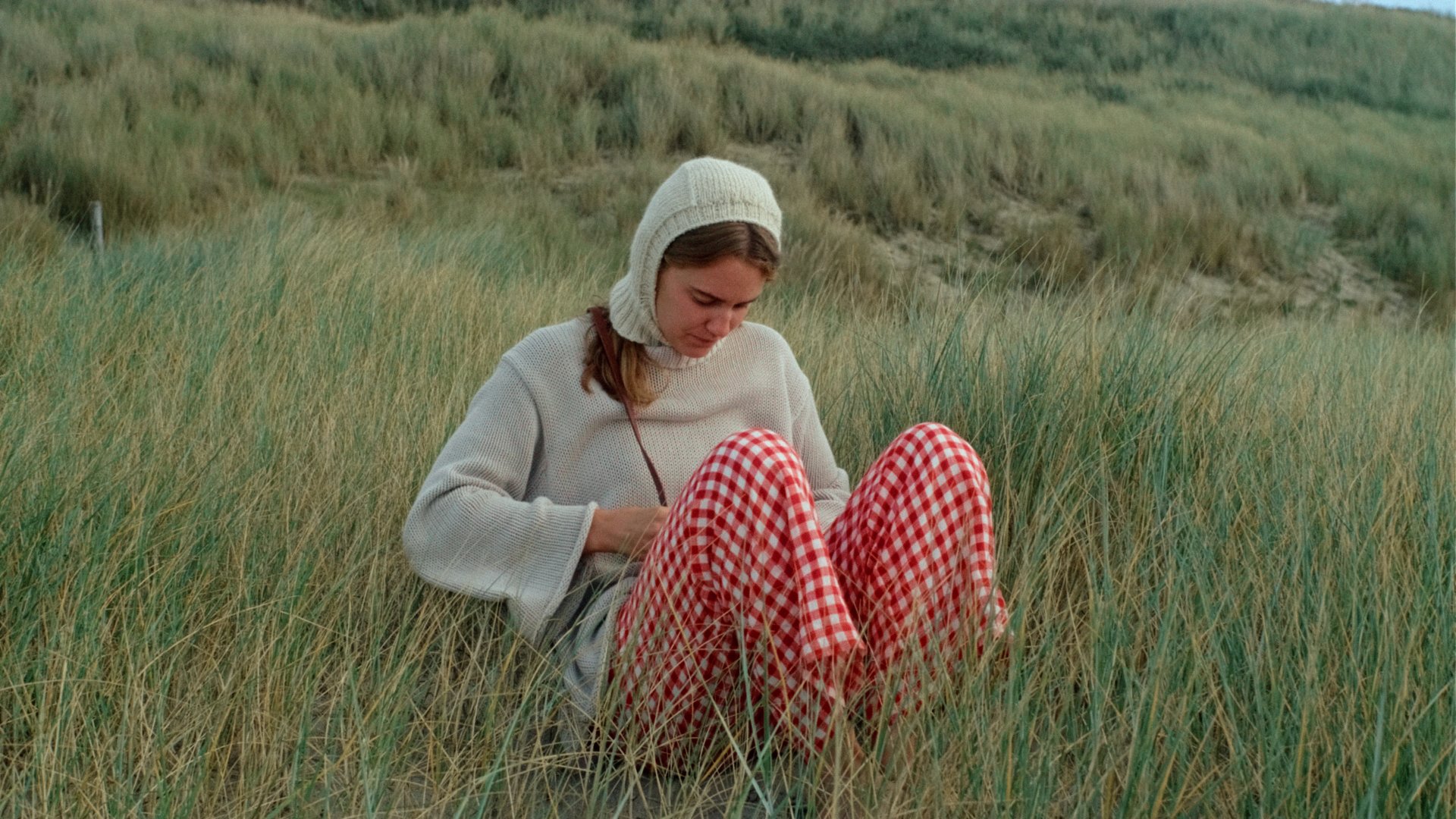 woman wearing linen trousers red gingham by the sea