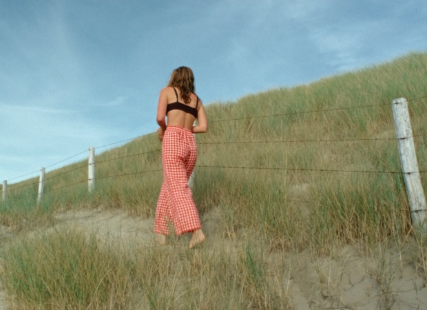 Back of a woman in relaxed-fit red gingham linen trousers