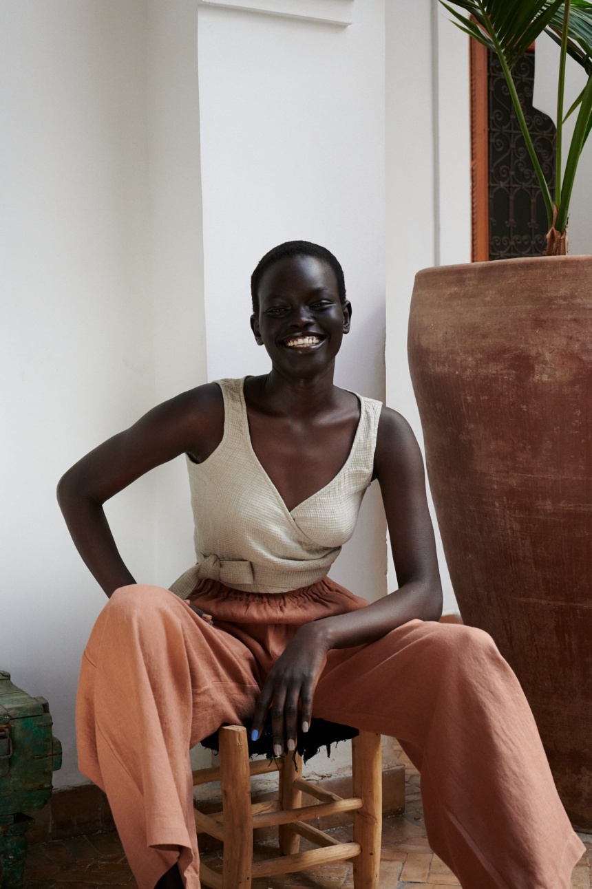 Waffle top made from textured linen with a wrap front, waist ties, and sleeveless cut. A cropped piece designed for warm weather styling.