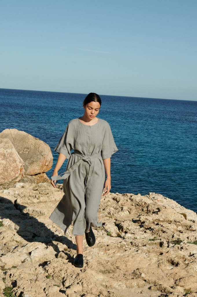 Athiec linen dress with snap-button closures, displayed on a hanger against a neutral background.