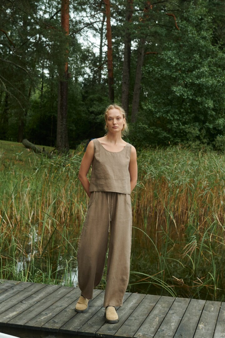 model is wearing wide leg barrel pants in brown linen
