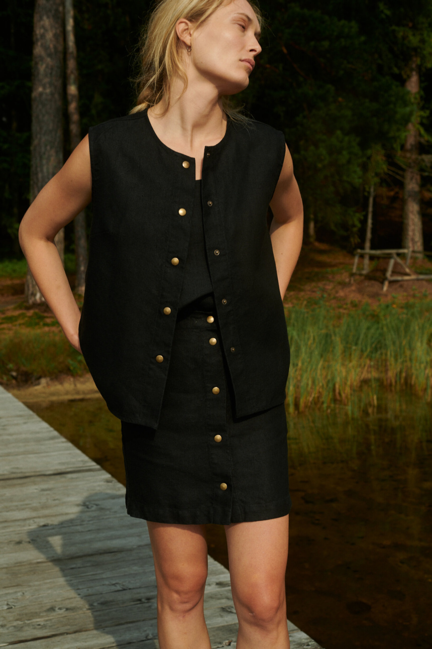 women is wearing black button up skirt made from heavy linen fabric