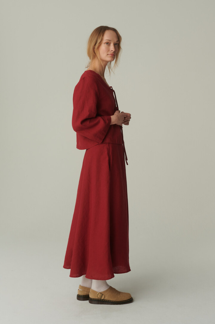 women is wearing linen maxi skirt with pockets in burgundy red color