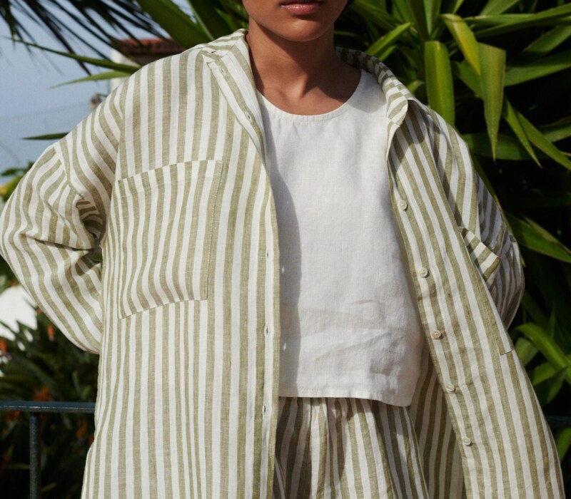 Woman in a lightweight oversized linen shirt with matching linen olive stripes shorts