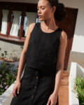 Model wearing a relaxed fit sleeveless black linen top and a matching linen skirt outfit
