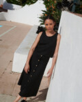 Model wearing a black midi skirt paired with a matching casual sleeveless black linen top