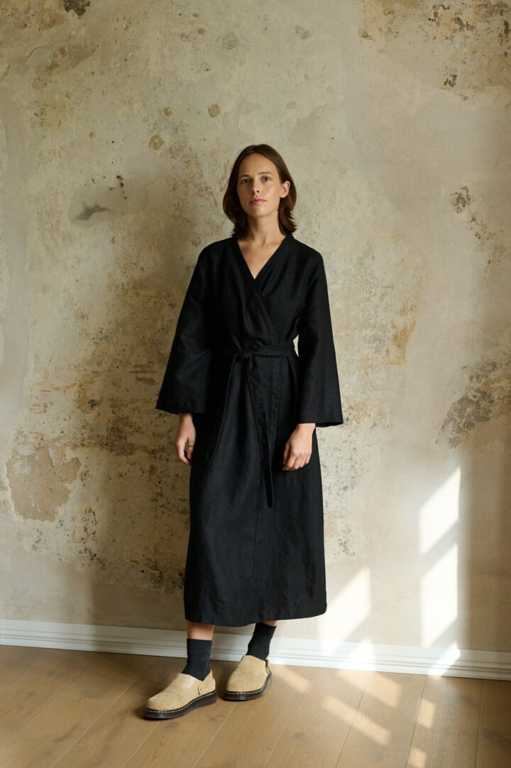 model wearing heavy black linen dress in wrap design