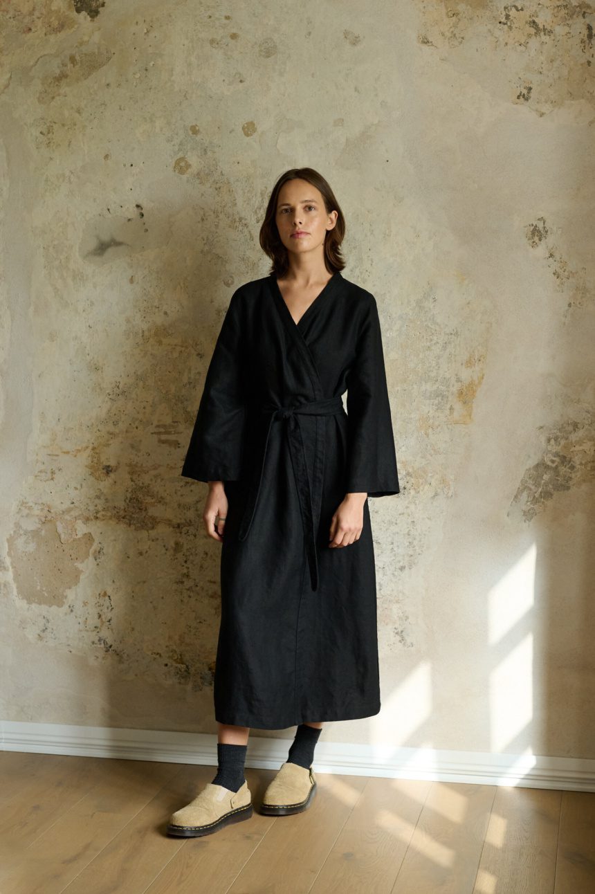 model wearing heavy black linen dress in wrap design