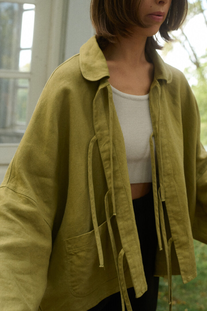 Model is wearing olive green linen jacket