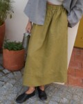 Model is wearing olive green linen skirt