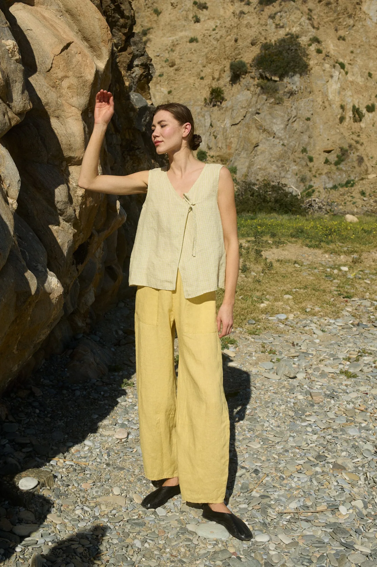 Model wearing a pale yellow checkered sleeveless linen top with tie closure, paired with matching butter yellow wide-leg linen pants