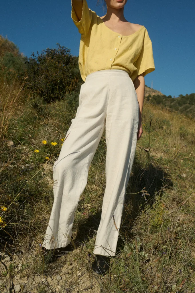 The front view showcases the vibrant sunshine-yellow linen top with a scoop neckline and button details, paired with breezy cream wide-leg pants for a light, effortless look