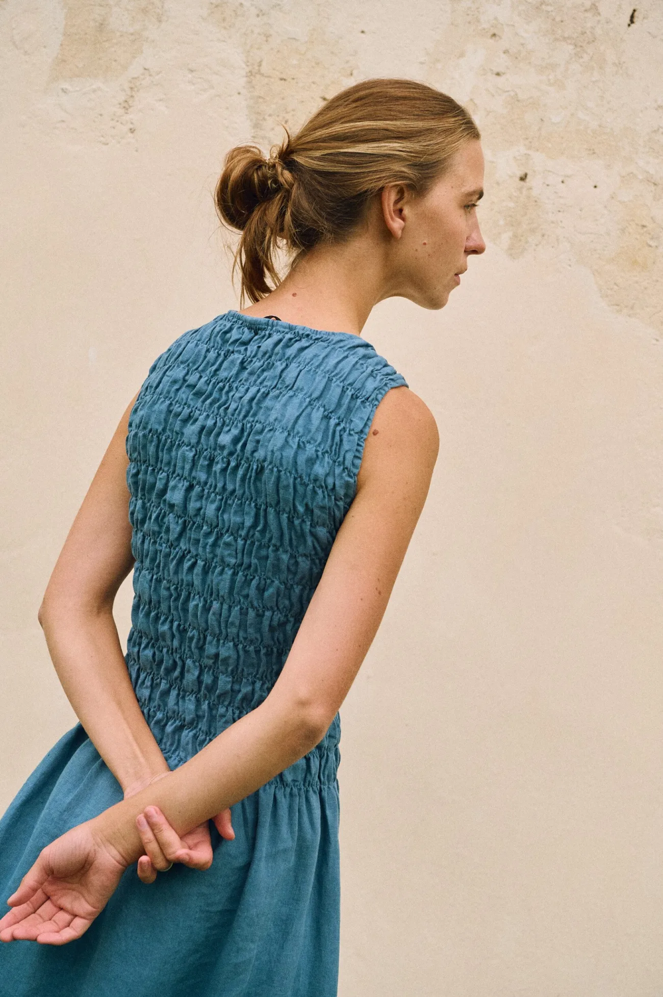 Sleeveless stellar blue linen dress with smocked bodice, shown from the back