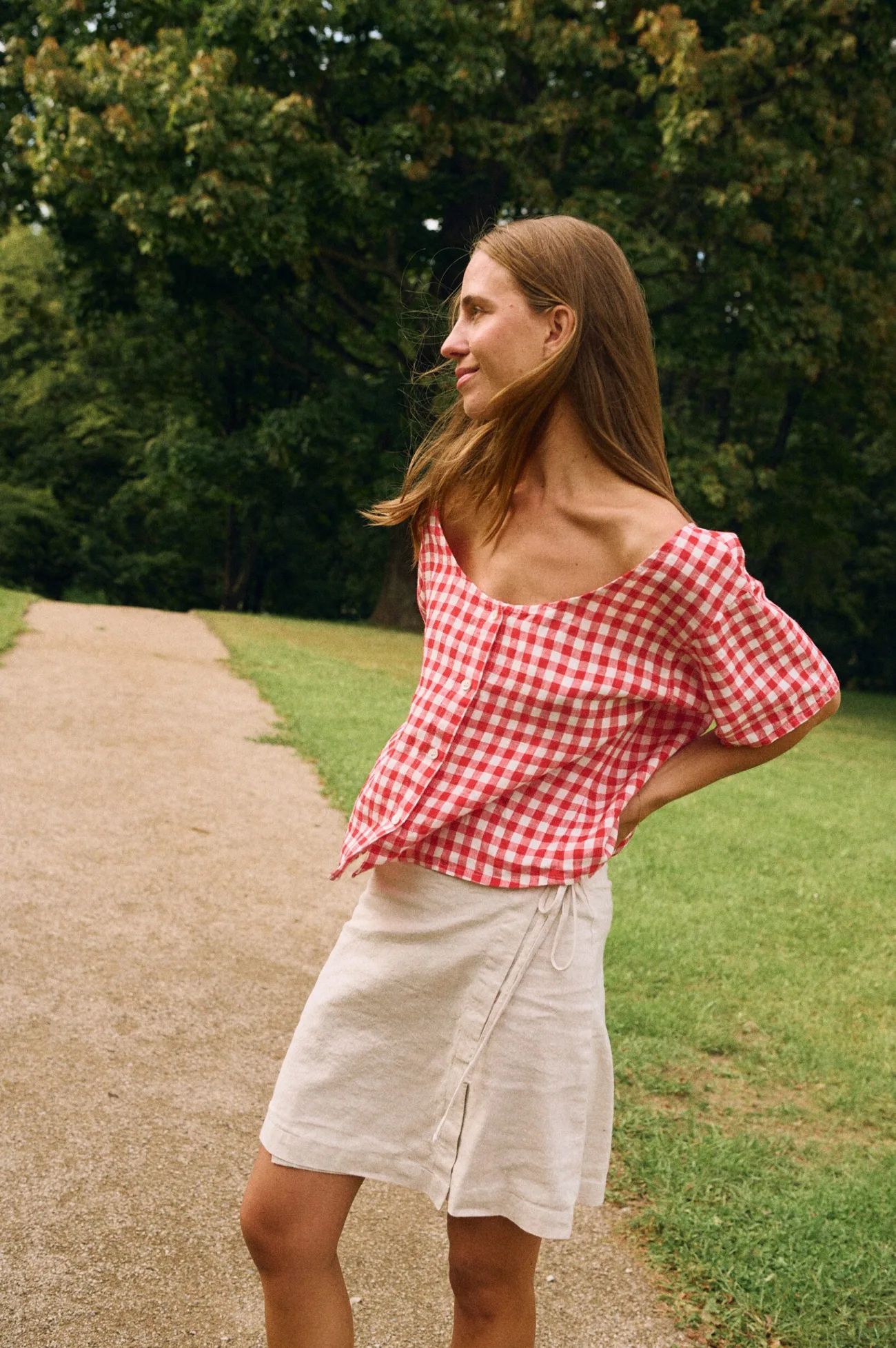 White cotton-linen wrap skirt with overlapping panel and tie fastening, worn with red gingham linen top