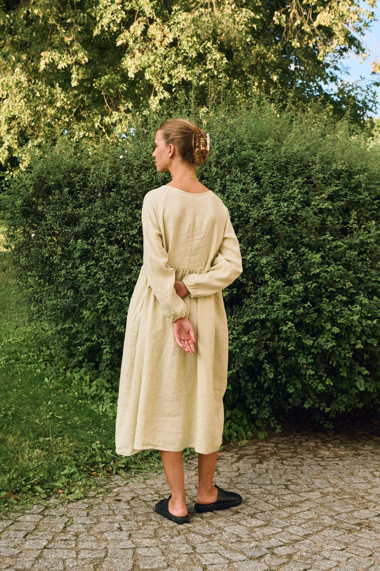 Back view of apple checks linen midi dress with loose drape and long sleeves
