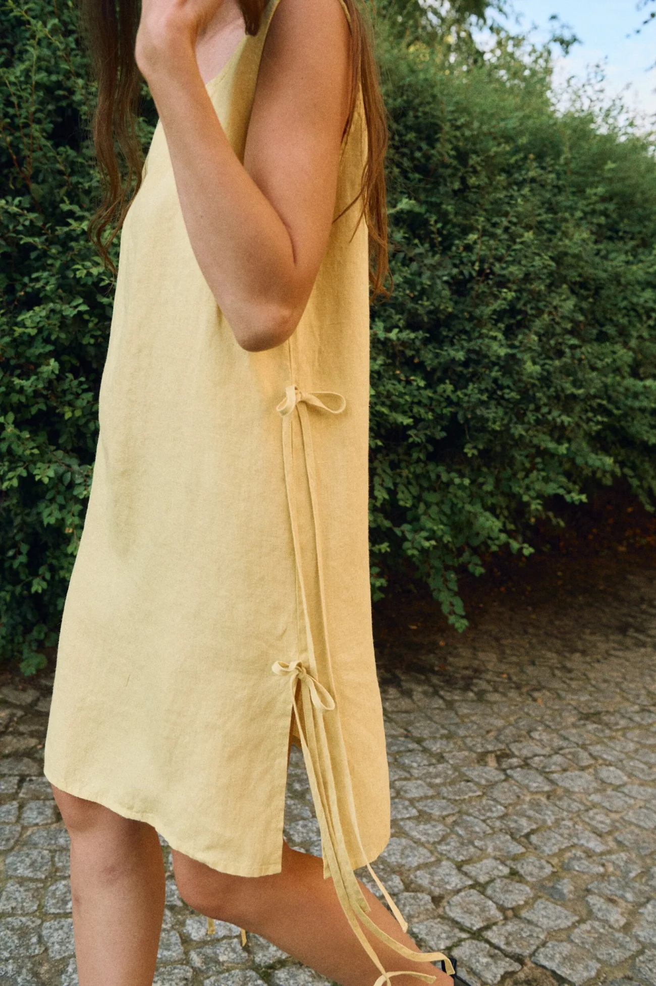 Sleeveless butter yellow linen midi dress with side slits and side tie details