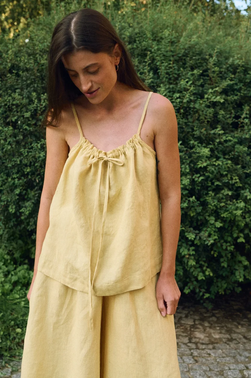 Detail view of yellow linen camisole top with adjustable drawstring front and thin straps