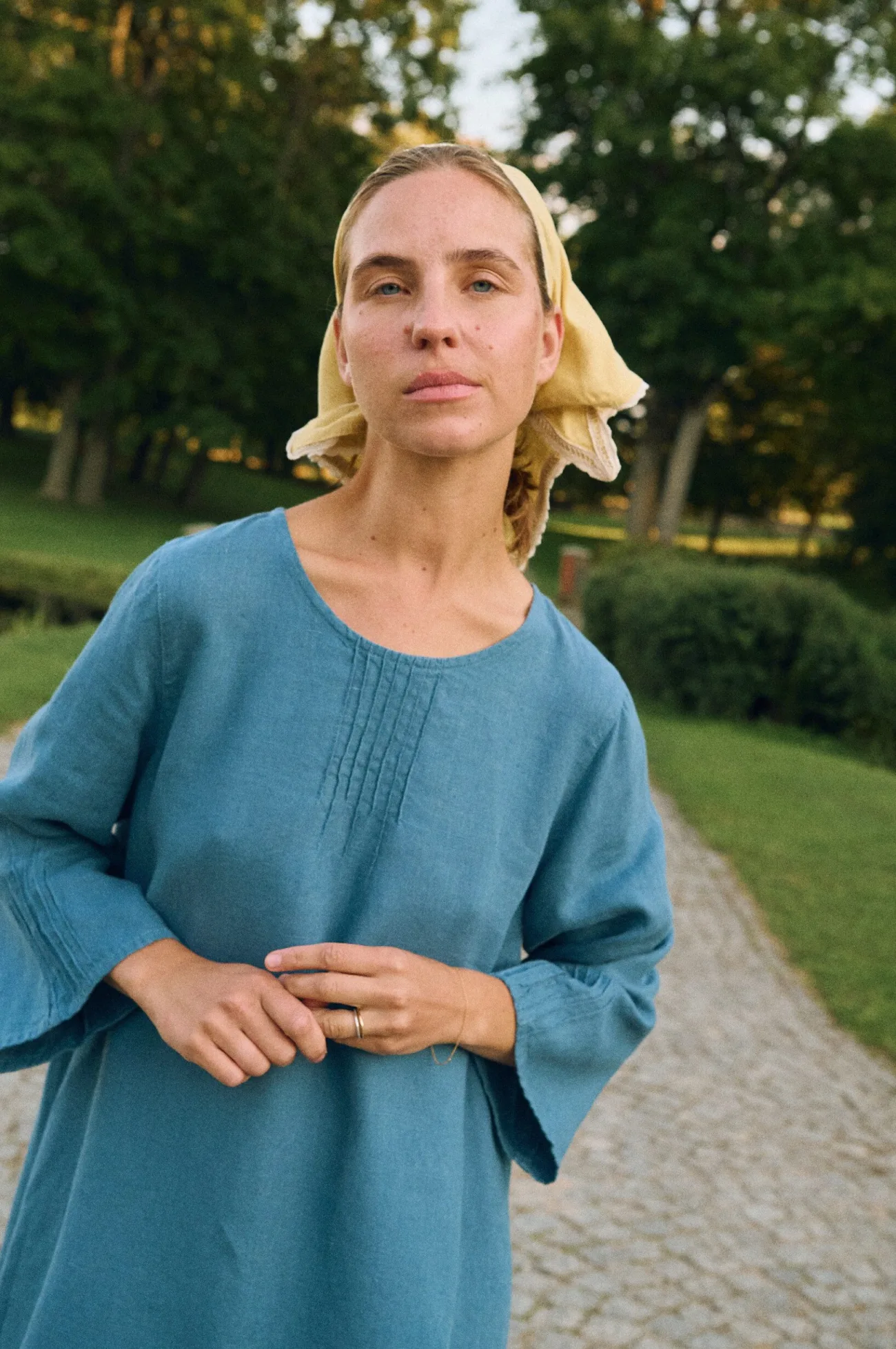 Close-up of stellar blue linen dress with decorative vertical stitching at neckline and cuffs