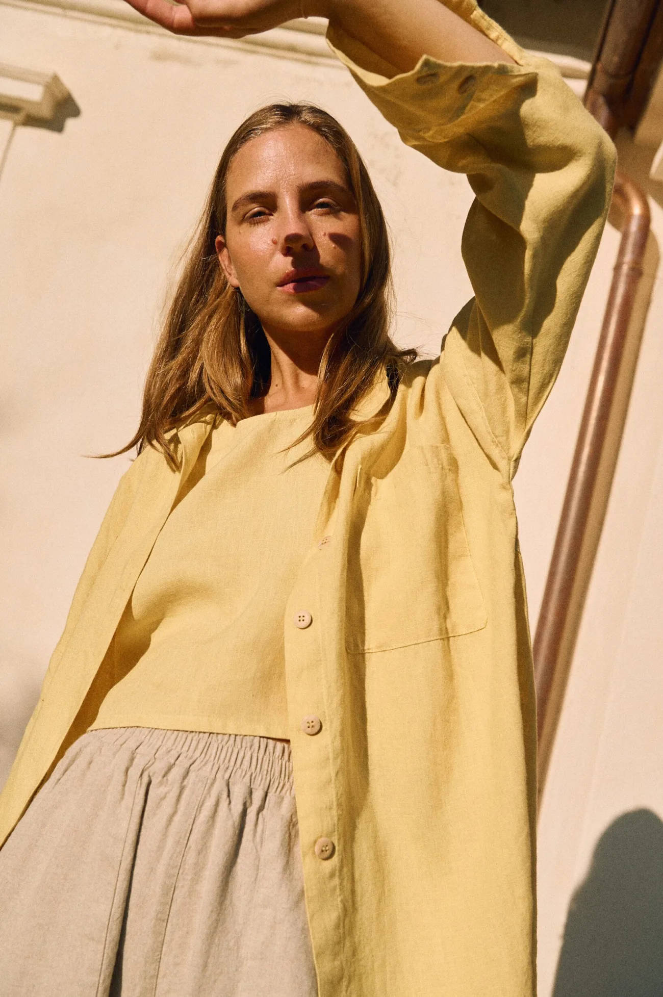 Butter yellow linen shirt with relaxed fit styled over cropped tank