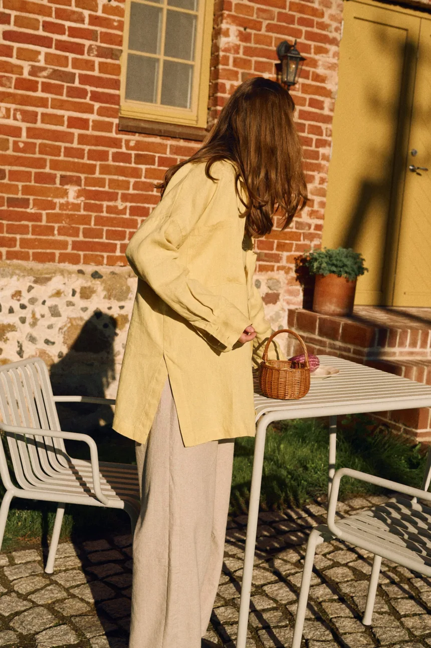 Side view of butter yellow linen shirt with relaxed oversized fit styled with natural cotton-linen pants