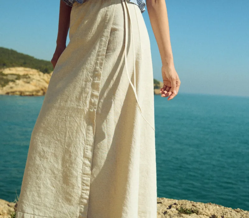 White cotton-blend wrap maxi skirt with tie closure, styled with a dusty blue mini gingham linen smocked peplum top
