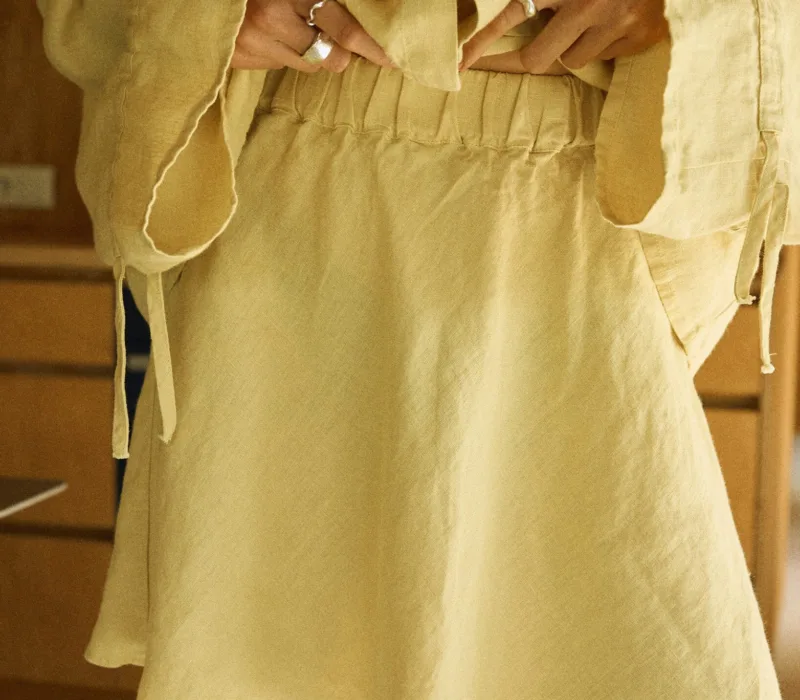 Butter yellow linen mini skirt with flared hem detail and fully elasticated waist