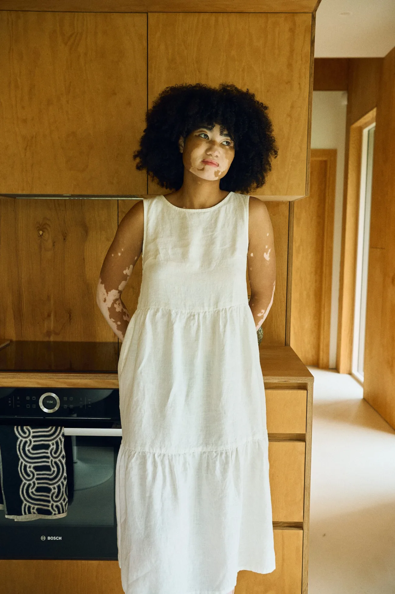 Front view of the Amalie tiered linen midi dress in milky white with a soft scoop neckline