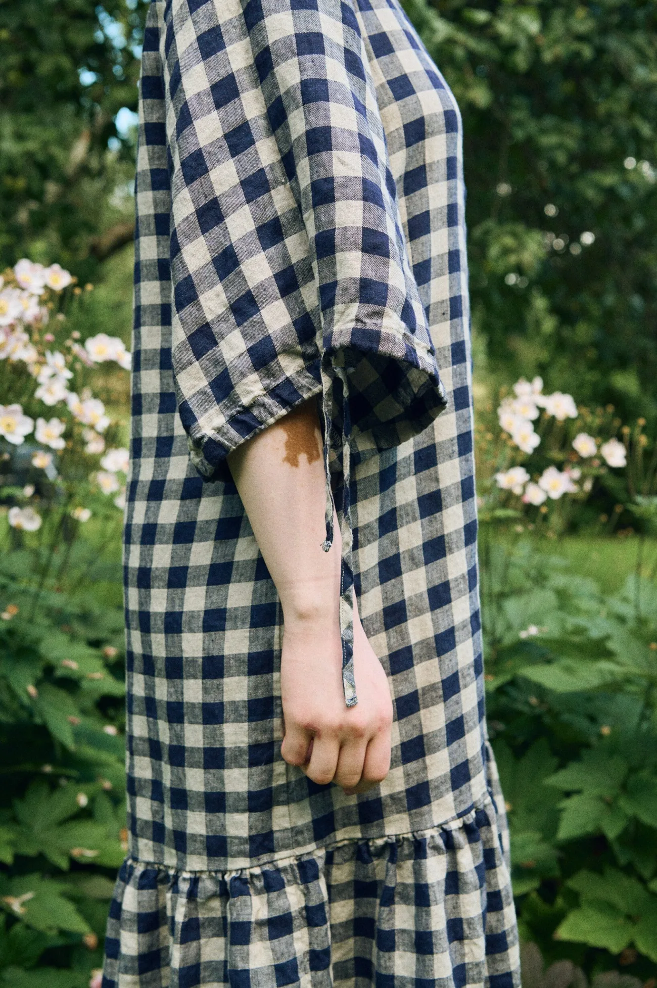 Close-up of the ¾ sleeves with functional string ties on the Vilte gingham dress
