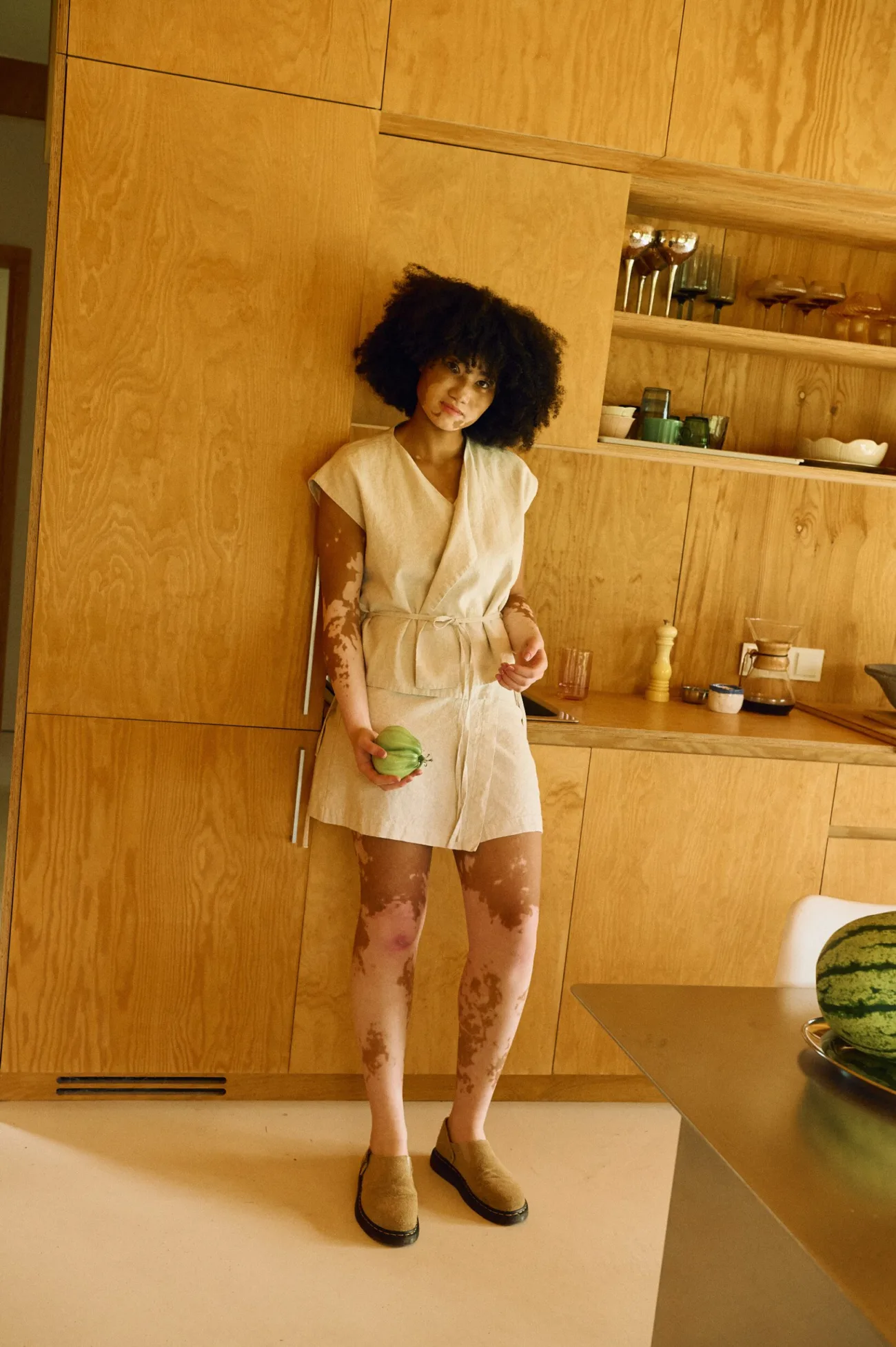 Model wearing a natural linen-cotton blend wrap vest paired with a matching linen wrap mini skirt