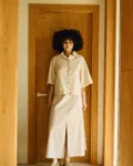 Natural linen-cotton set featuring a boxy shirt jacket worn over a high-waisted midi skirt