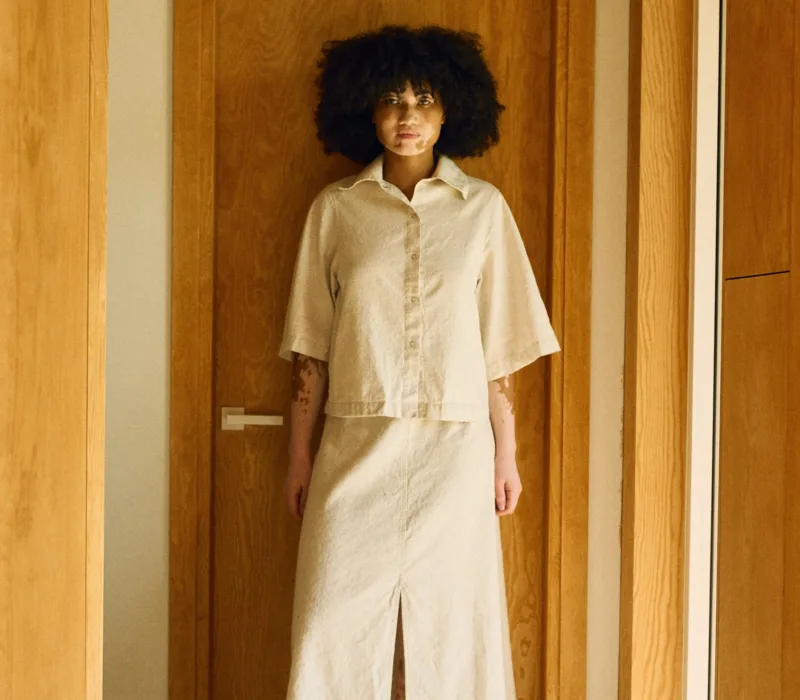 Natural linen-cotton set featuring a boxy shirt jacket worn over a high-waisted midi skirt