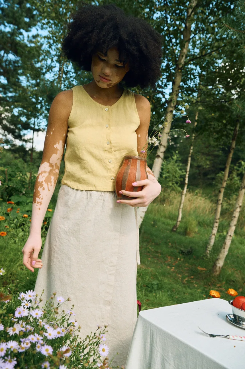 Outfit featuring a sleeveless cropped linen top and a long A-line wrap skirt in neutral tones