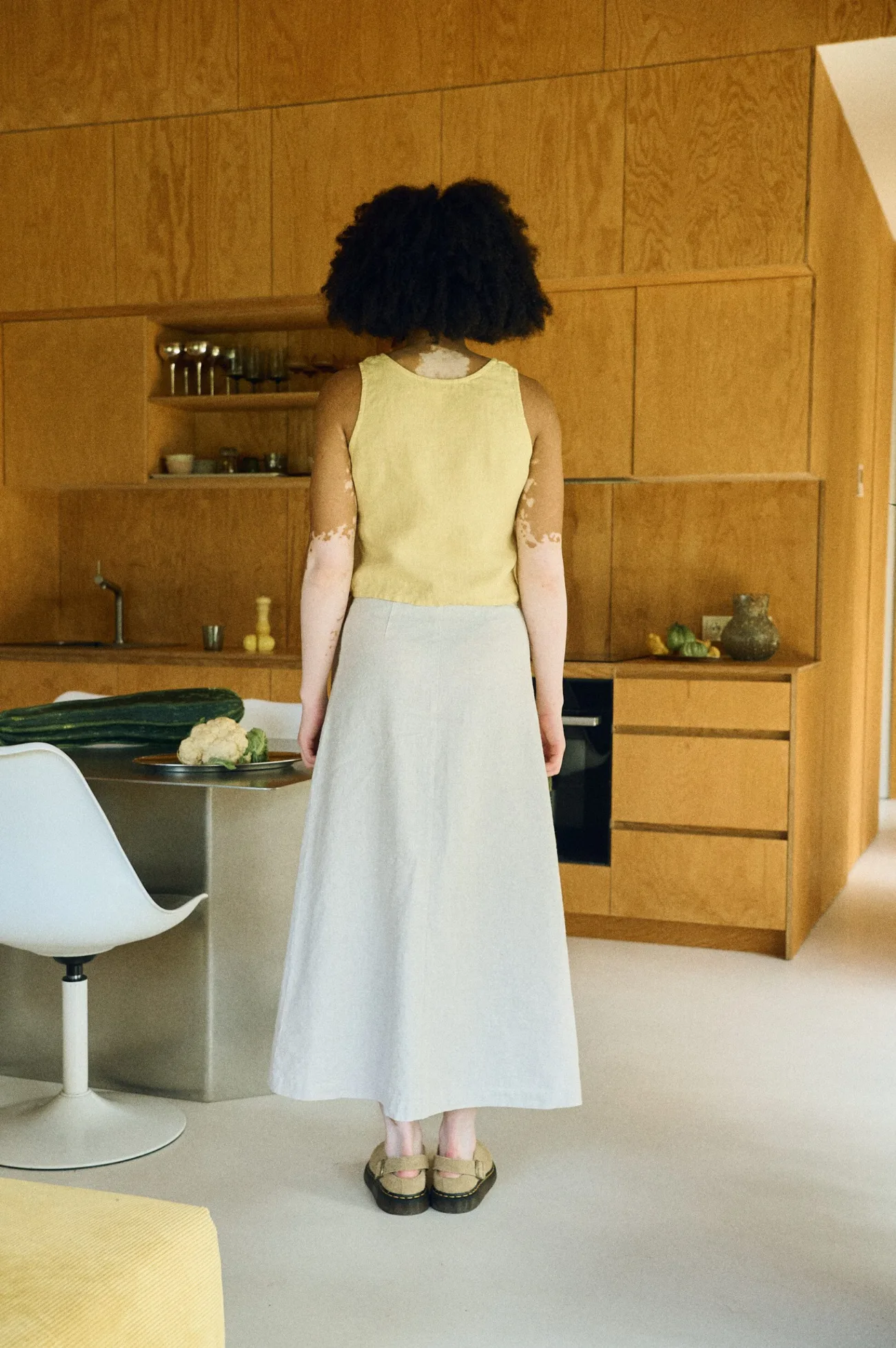 Back view showing the cropped length of the top and the elegant drape of the maxi wrap skirt