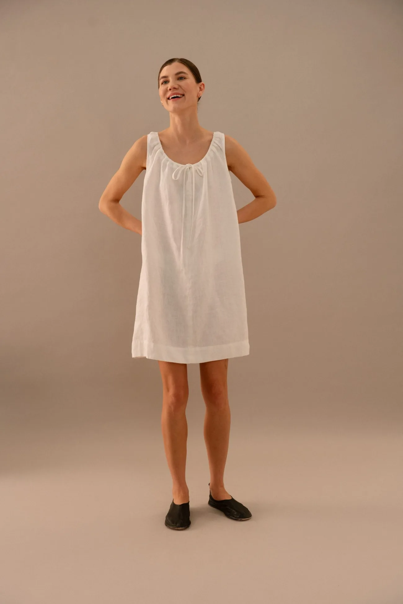 White linen A-line dress with soft gathered neckline and relaxed silhouette