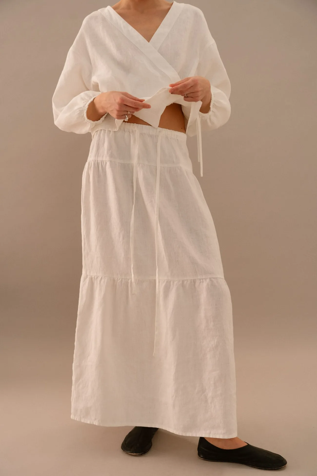 White linen tiered maxi skirt with soft gathered panels and flowing drape