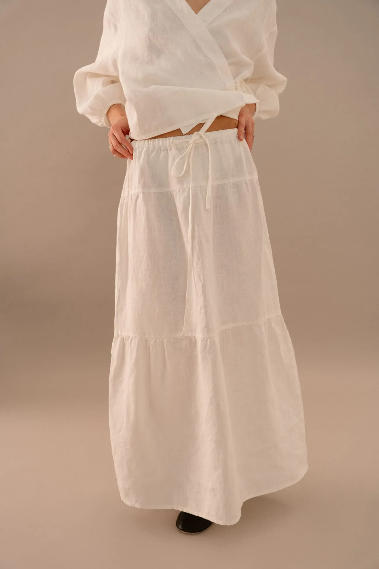Close-up of milky white linen skirt featuring elastic waist and adjustable drawstring