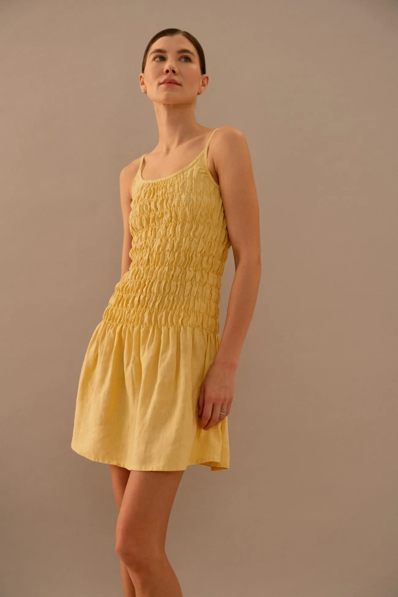 Close-up of butter yellow linen dress with textured smocked bodice