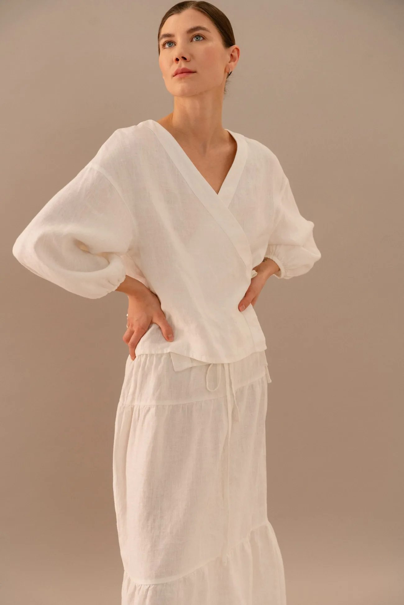 Milky white linen wrap blouse with side tie closure and voluminous sleeves paired with matching skirt